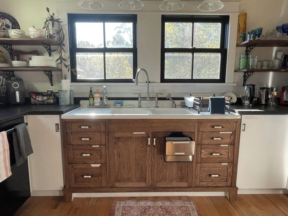 Restored cast iron sink, compost bin, coffee makers, dishes, drinking wares.