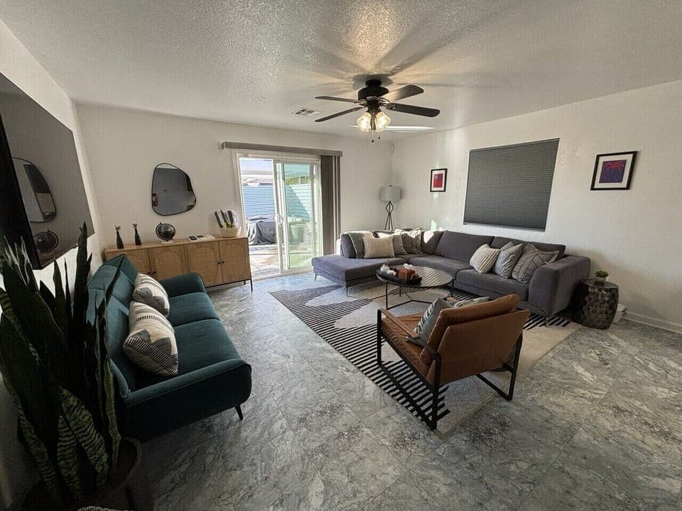 Inviting living room w/ comfy seating, ceiling fan, and easy flow for lounging, chatting, or movie nights together.