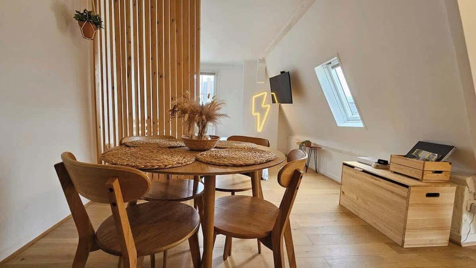 Chambre avec lit double et télévision murale HD.
Chambre semi ouverte sur l'espace repas pour deux personnes et la cuisine.