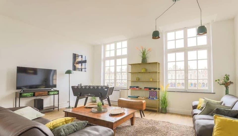 Salon avec 3 grands canapés, TV HD Système son, baby-foot et jeux de société.

Vue magnifique sur la Grand Place.