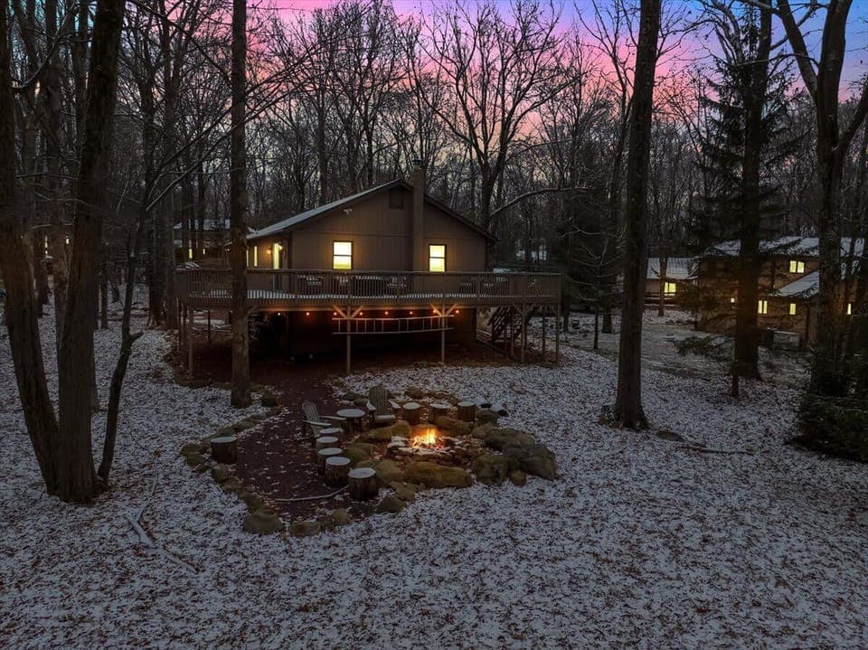 Enchanting Outdoor Escape – A stunning twilight view of the home with a glowing firepit, creating a magical and serene outdoor ambiance.
