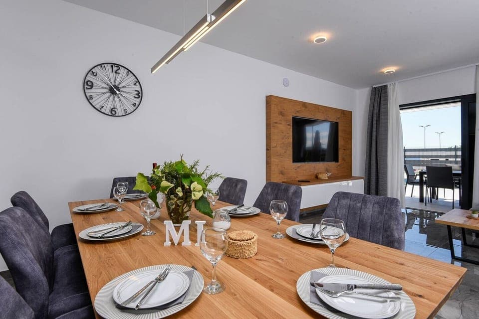 Dining and living area with TV in luxury sea view villa
