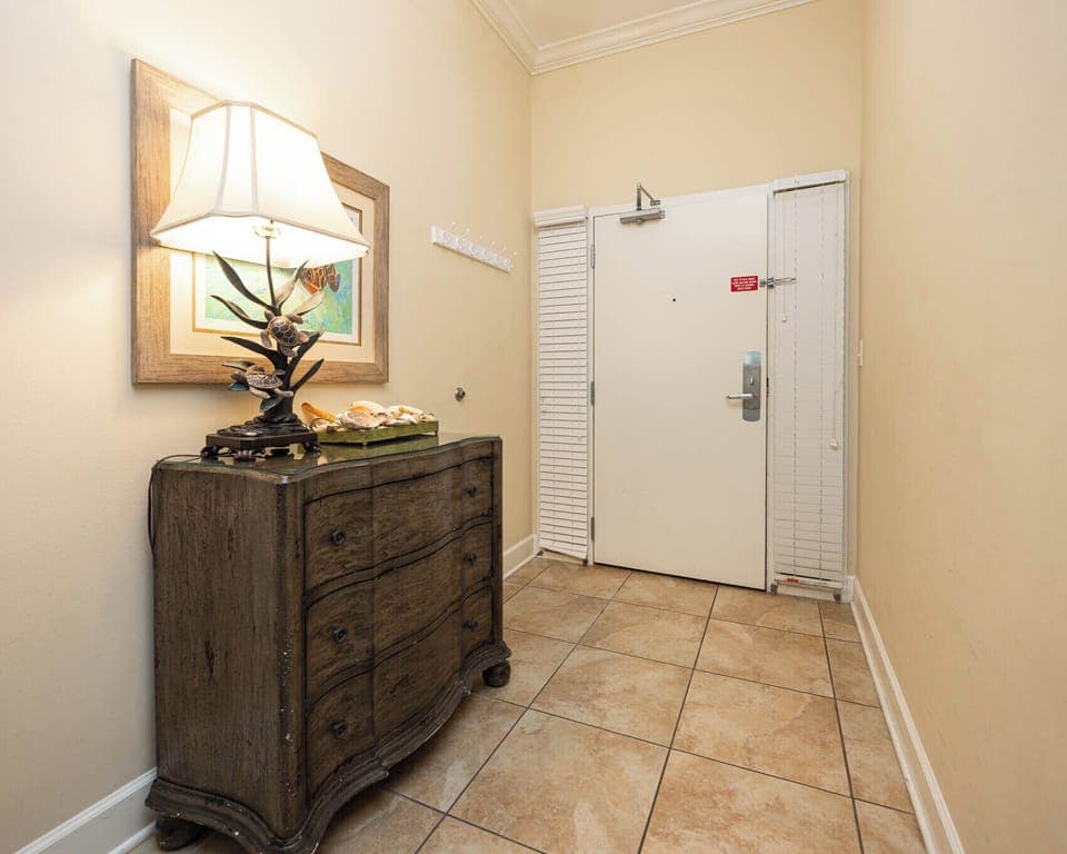 Welcoming entryway featuring a stylish chest, seashell decor, and warm lighting for a cozy atmosphere