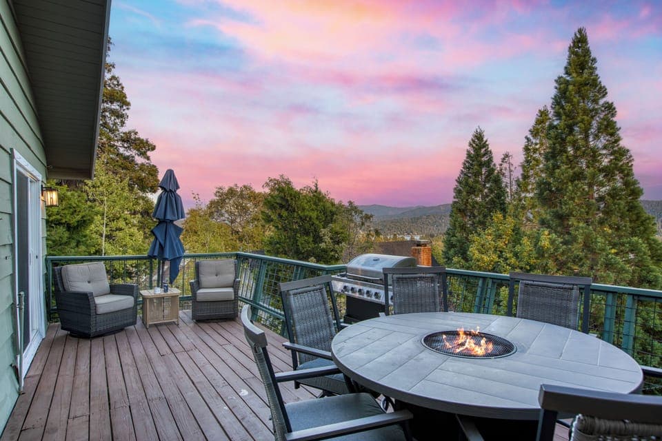 Deck with a fire pit table, grill, and seating area.