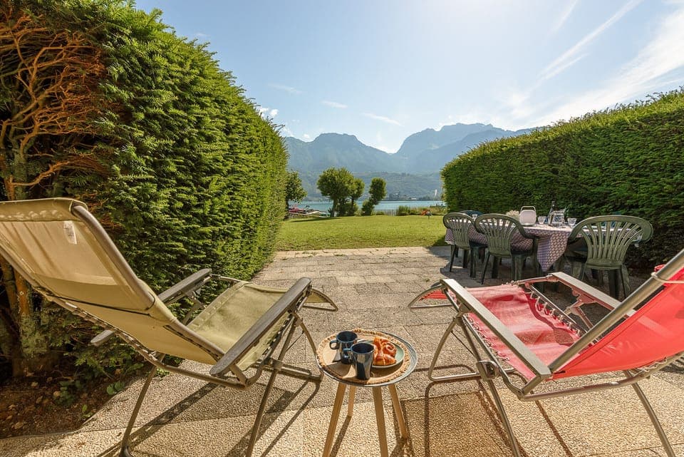 Large 40m² terrace with views of the lake and mountains, dining table, and relaxation area with outdoor furniture provided