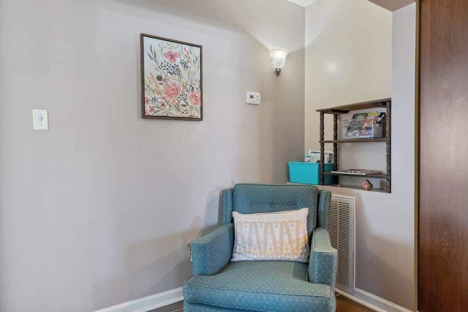 Cozy seating area for one near the kitchen and bedrooms, perfect for reading a book.