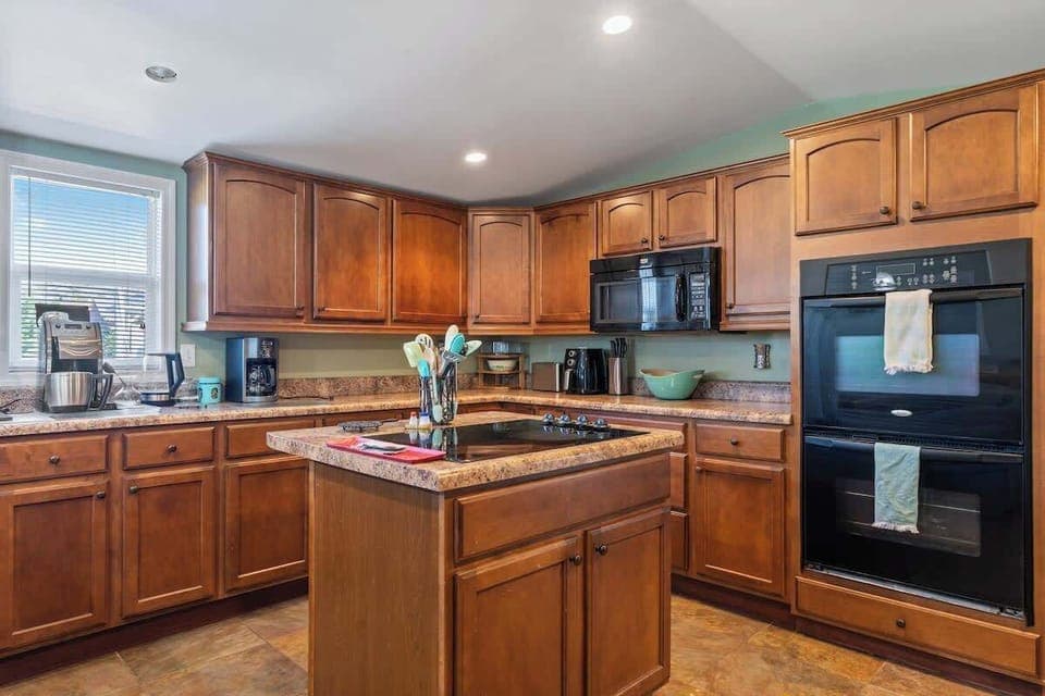 Our kitchen is fully equipped for a great meal, featuring countertop cooking, a double oven, microwave, drip coffee maker, pots, pans, dishes, and plenty of extras.