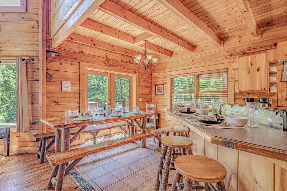 Spacious dining area with large family-style table and fully equipped kitchen—ideal for group meals and gatherings.