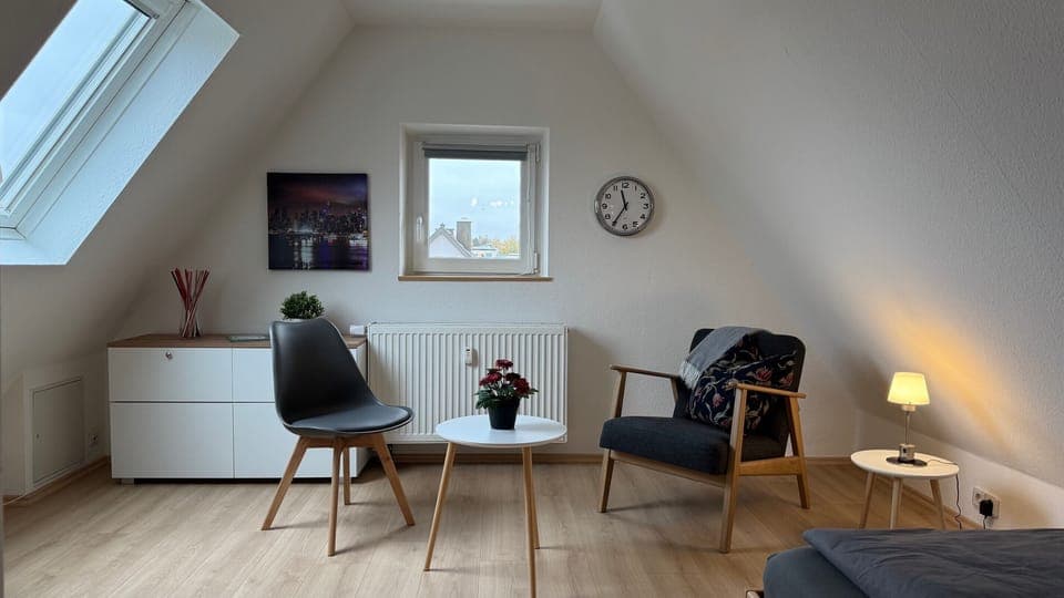 Wohnbereich mit Sessel und Komode.