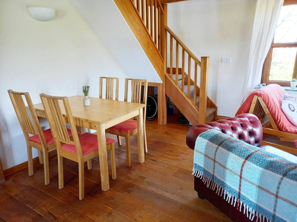 Dining area with table and four chairs, stairs to first floor