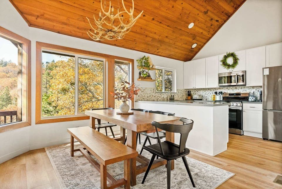 Gather for meals together at the dining table, with seating for the whole family, opens to the living room and the kitchen.