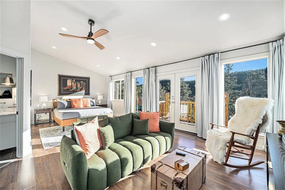 - Wake up to treetop vistas from a sun soaked room with private deck access
- Stretch out on the stylish king bed or relax on the bold green lounge sofa
- Cozy up in the sheepskin rocker or swing open the doors for mountain air bliss