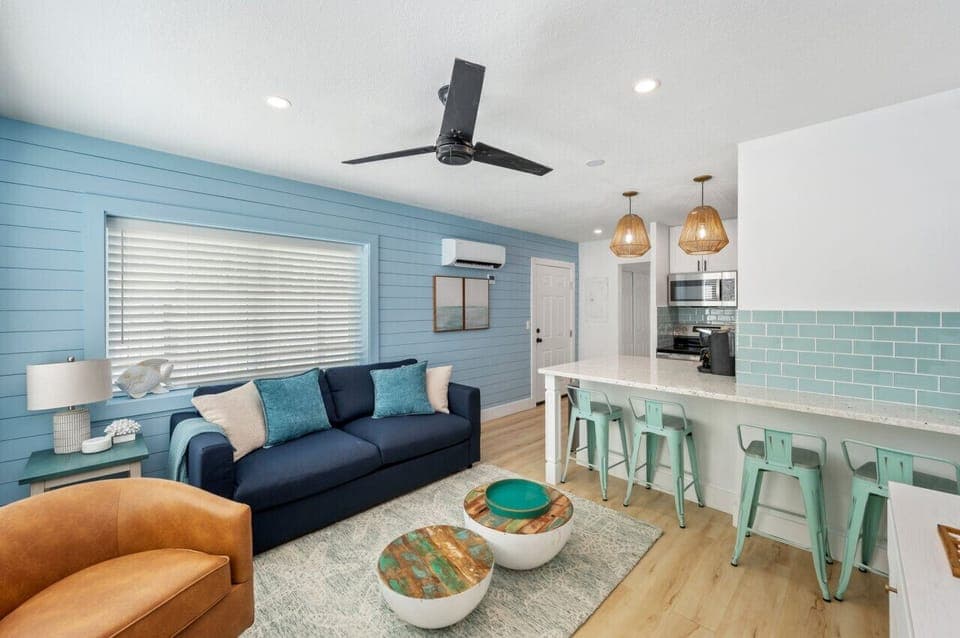 Cozy living room with a comfy sofa bed, perfect for relaxing with a sneak peek of the modern kitchen just beyond. A space that blends comfort and convenience!