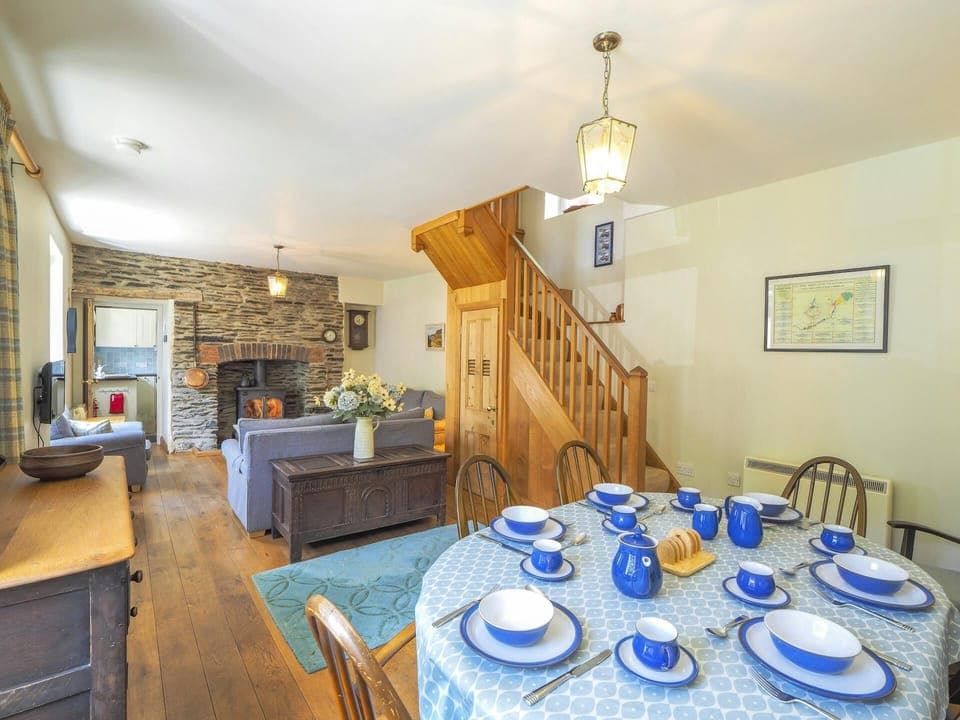 Open plan living room, dining table set for breakfast, 6 chairs, stairs to first floor, sofas