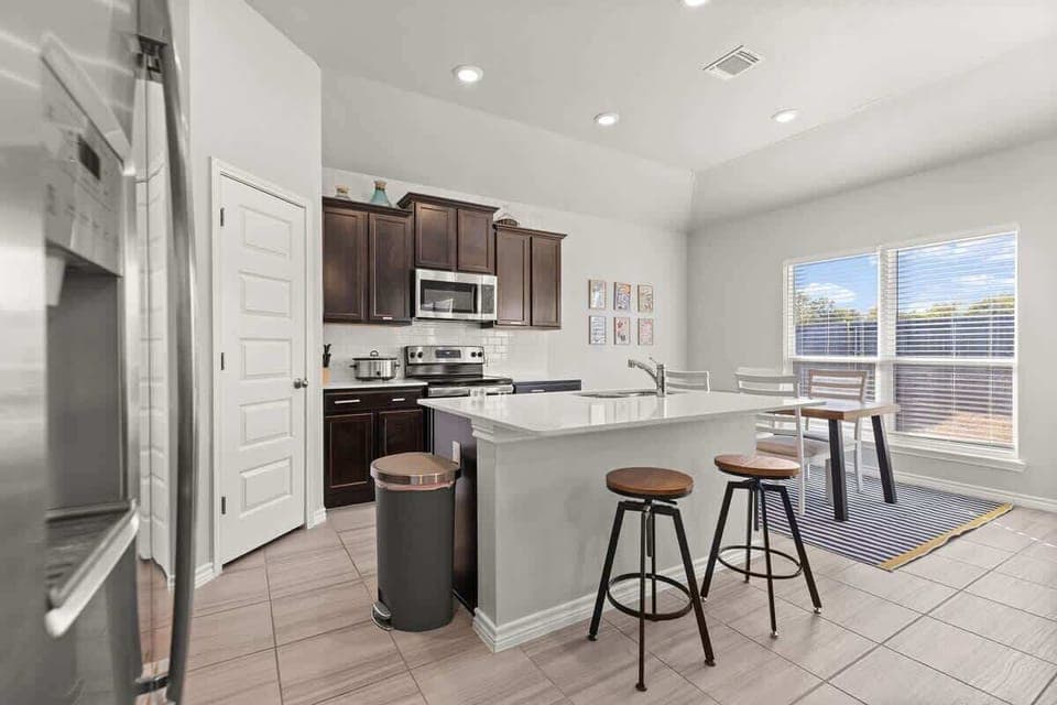 Kitchen Delight: Modern space with a large island, sleek appliances, and bright windows!