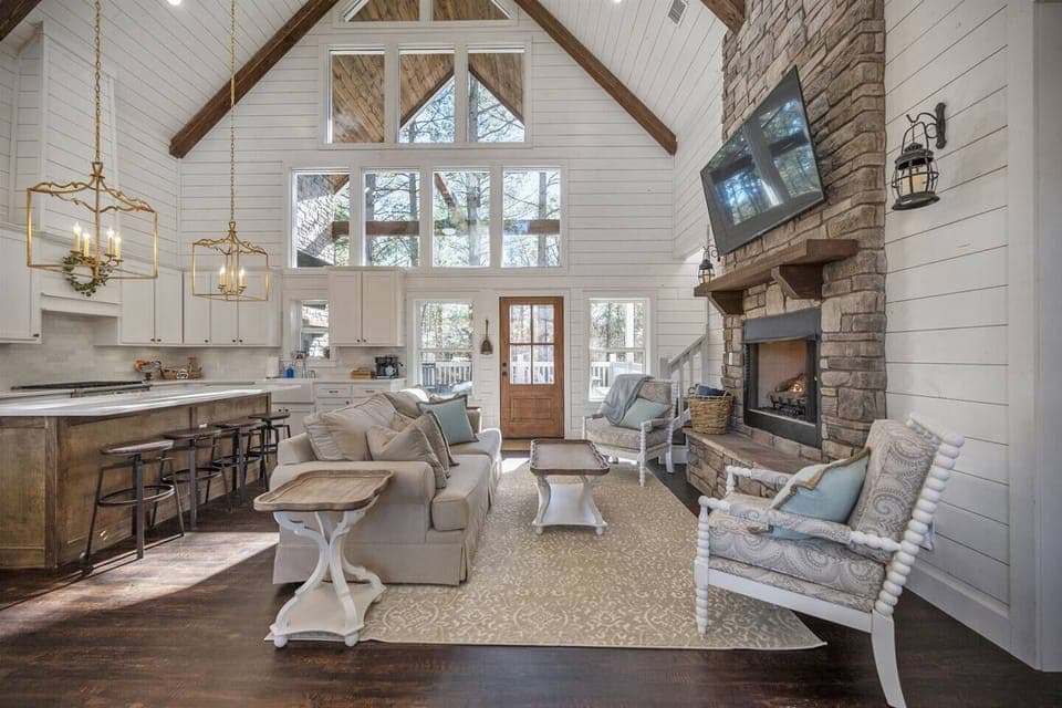 The great room features a vaulted ceiling and expansive windows, creating a bright and airy space that’s perfect for relaxing and enjoying your vacation.