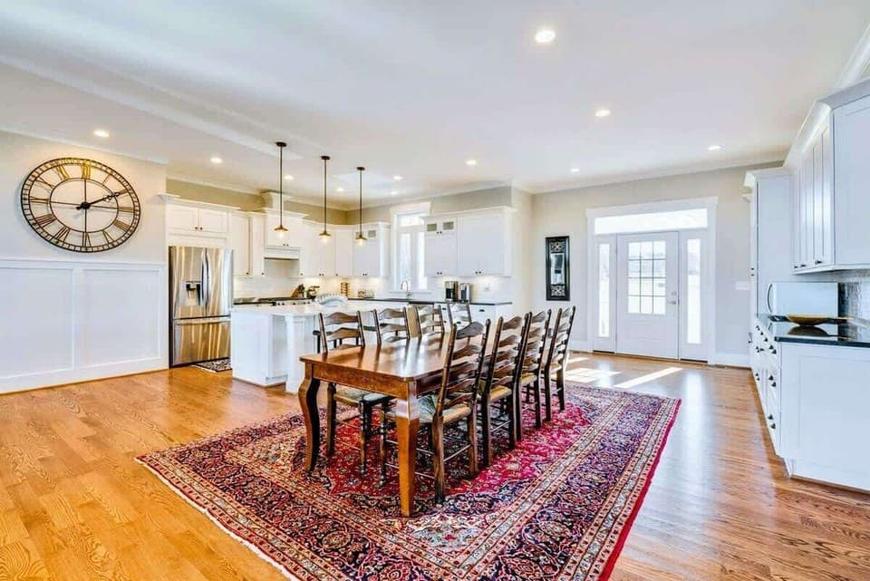 Bright, open dining and kitchen area with a large wooden table and stylish decor, ideal for family meals and gatherings