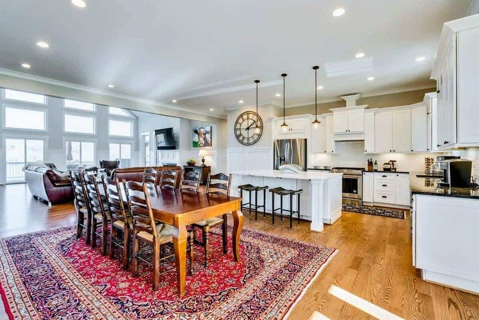 Open-concept kitchen and dining area with a large wooden table, modern appliances, and ample natural light