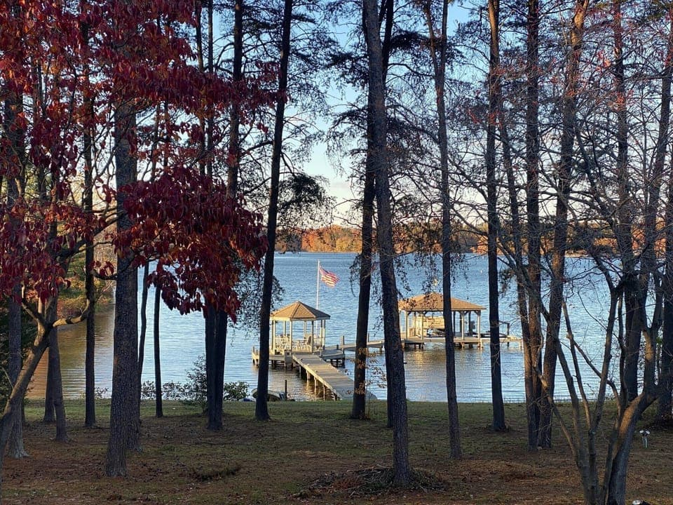Breathtaking autumn view of a dock framed by colorful trees, with a peaceful lake in the background
