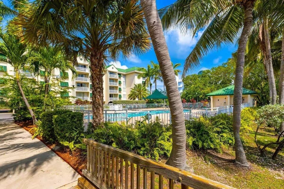 Lush tropical plantings around large size pool with hot tub.