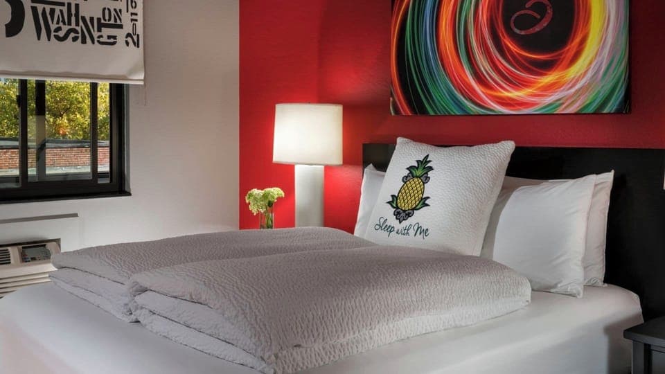 Unwind in crisp linens beneath bold art and soft light.