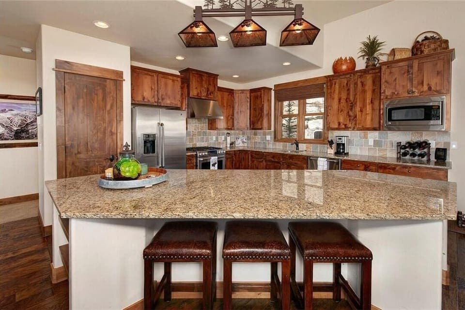 Full kitchen featuring stainless steel appliances, and breakfast bar seating 3.