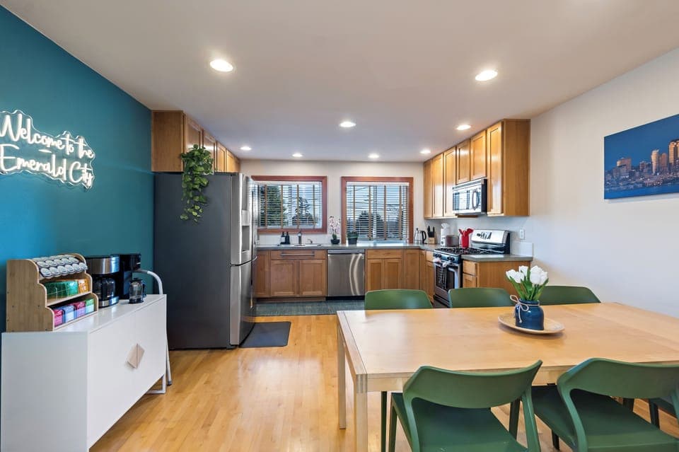 Stylish kitchen with stainless appliances, coffee bar, and fun Seattle neon vibe