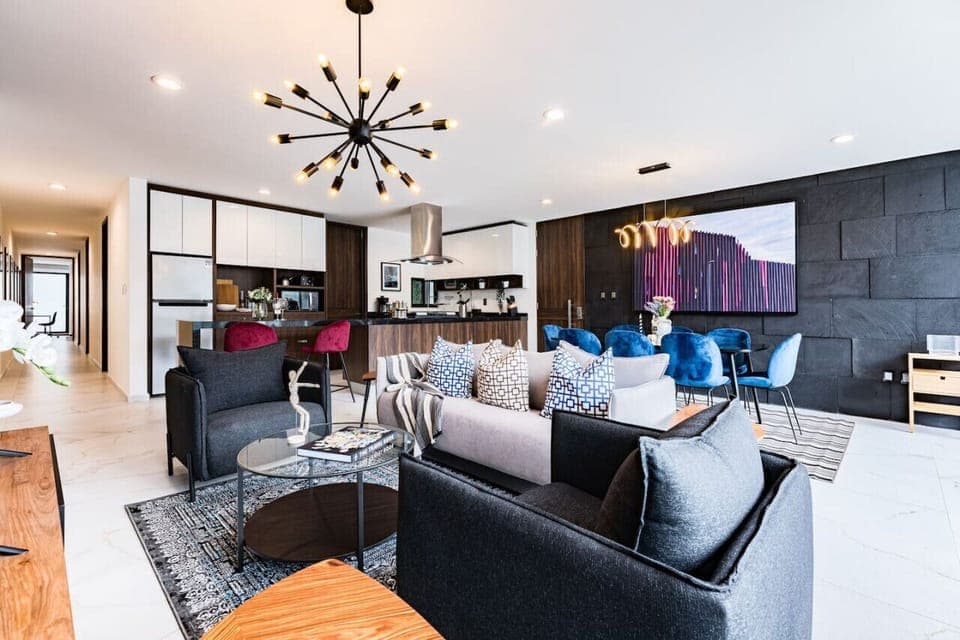 Inviting and spacious living room with unique light fixtures and cozy seating, perfect for entertaining.