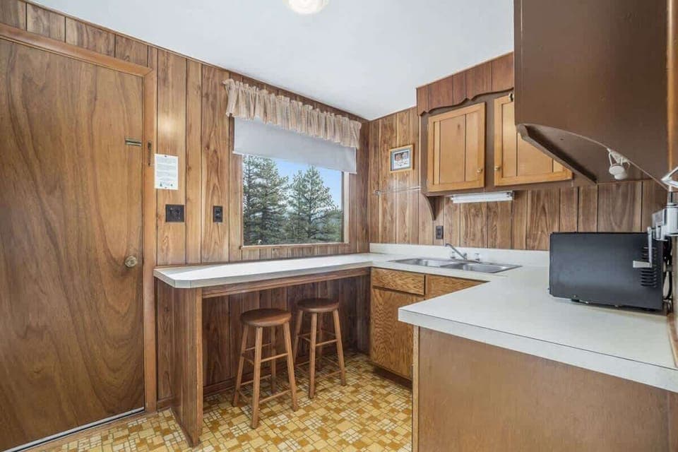Full kitchen with two bar stools with extra seating.