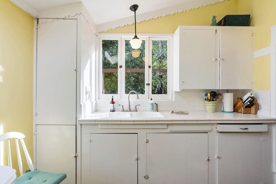 A cheery yellow and white kitchen with modern touches.