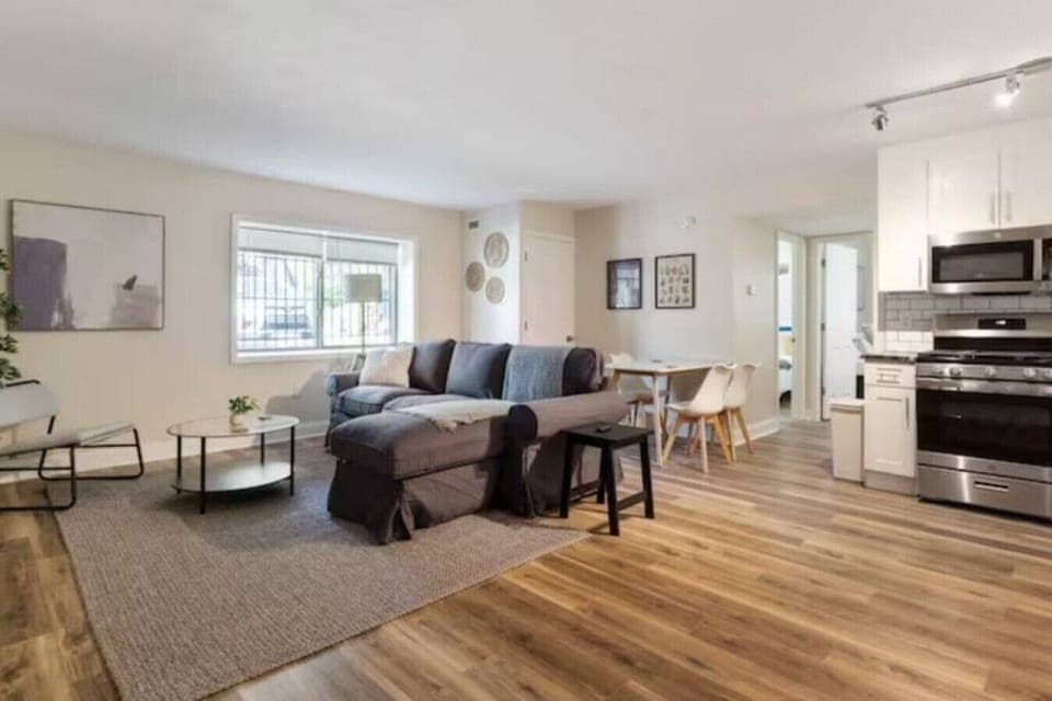 The living room’s plush seating beckons you to sink in and relax, surrounded by light and airy decor.