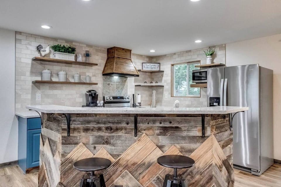 Hand-crafted range hood, open shelves, and kitchen island. Provided coffee, tea, and hot cocoa Keurig pods. Oven, dishwasher, microwave, full-sized refrigerator, Keurig, sink, cooking utensils,  pots & pans, baking sheet, and more!