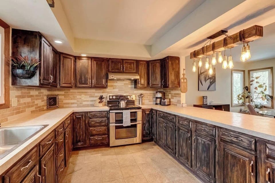 Custom-cabinets and kitchen island. Provided coffee, tea, and hot cocoa. Oven, dishwasher, microwave, full-sized refrigerator, coffee maker, kettle, sink, cooking utensils,  pots & pans, baking sheet, and more!