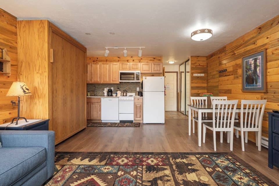 Your cozy cabin retreat at 564 SilverCreek Inn blends rustic charm with modern comfort—warm wood walls, full kitchen, and dining space for memorable meals.