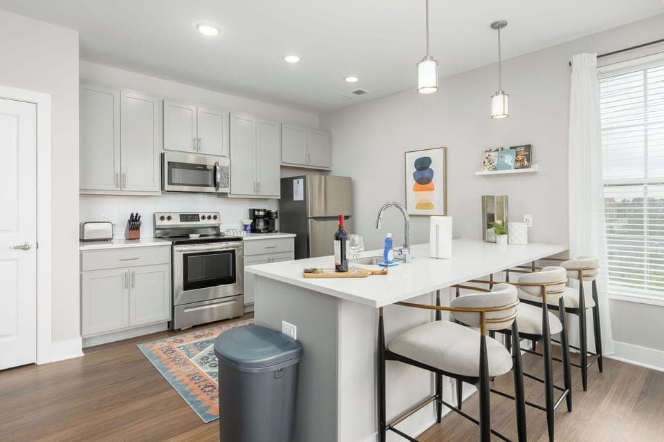 The kitchen in this apartment is massive and offers comfortable seating with designer Arhaus counter stools. 