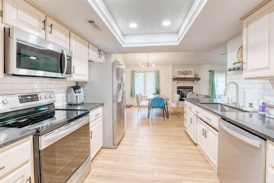 A symphony of stainless steel and soft neutrals. This kitchen whispers of comfort and modern ease. 