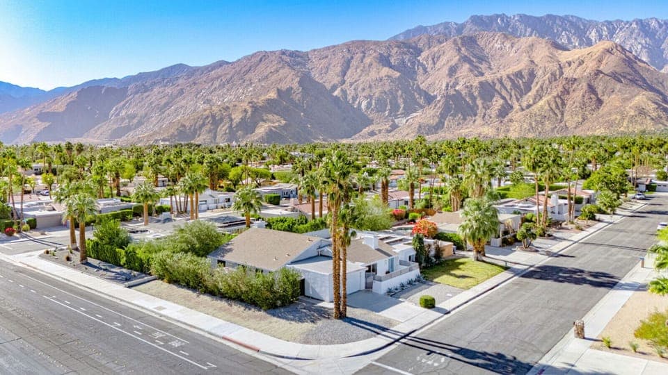 Elevated view of the surrounding neighborhood w/ mountain backdrops and wide-open skies.