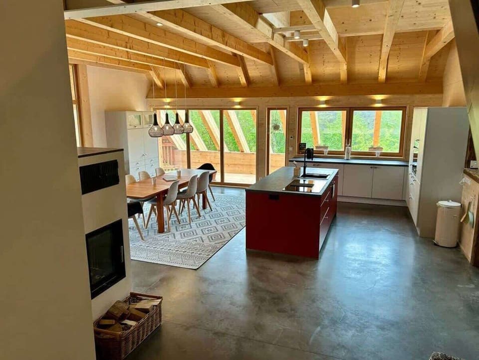 Eine vollausgestattete Küche mit hochwertigen Geräten und einer eleganten roten Insel. Hier treffen Design und Funktion aufeinander: luxuriös, stilvoll und perfekt für kulinarische Kreationen. Ein Raum, der Kochen zum Erlebnis macht!