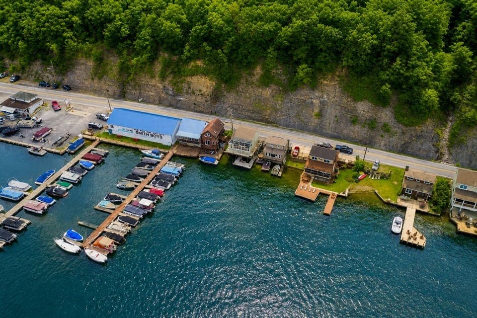 Nestled at the edge of a serene lake, this charming dock features a row of inviting, comfortable chairs, perfect for relaxing and enjoying the peaceful surroundings. The chairs, crafted from weather-resistant materials, are designed for comfort with 