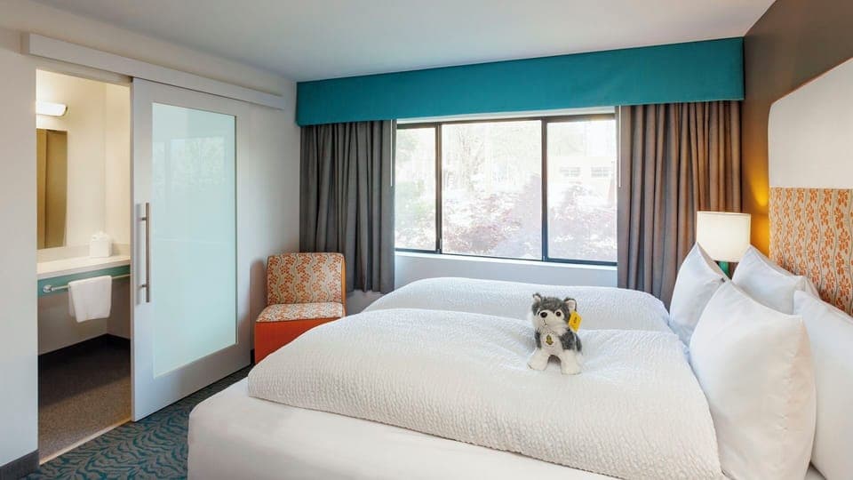 Sink into crisp bedding beneath wide windows and soft light.