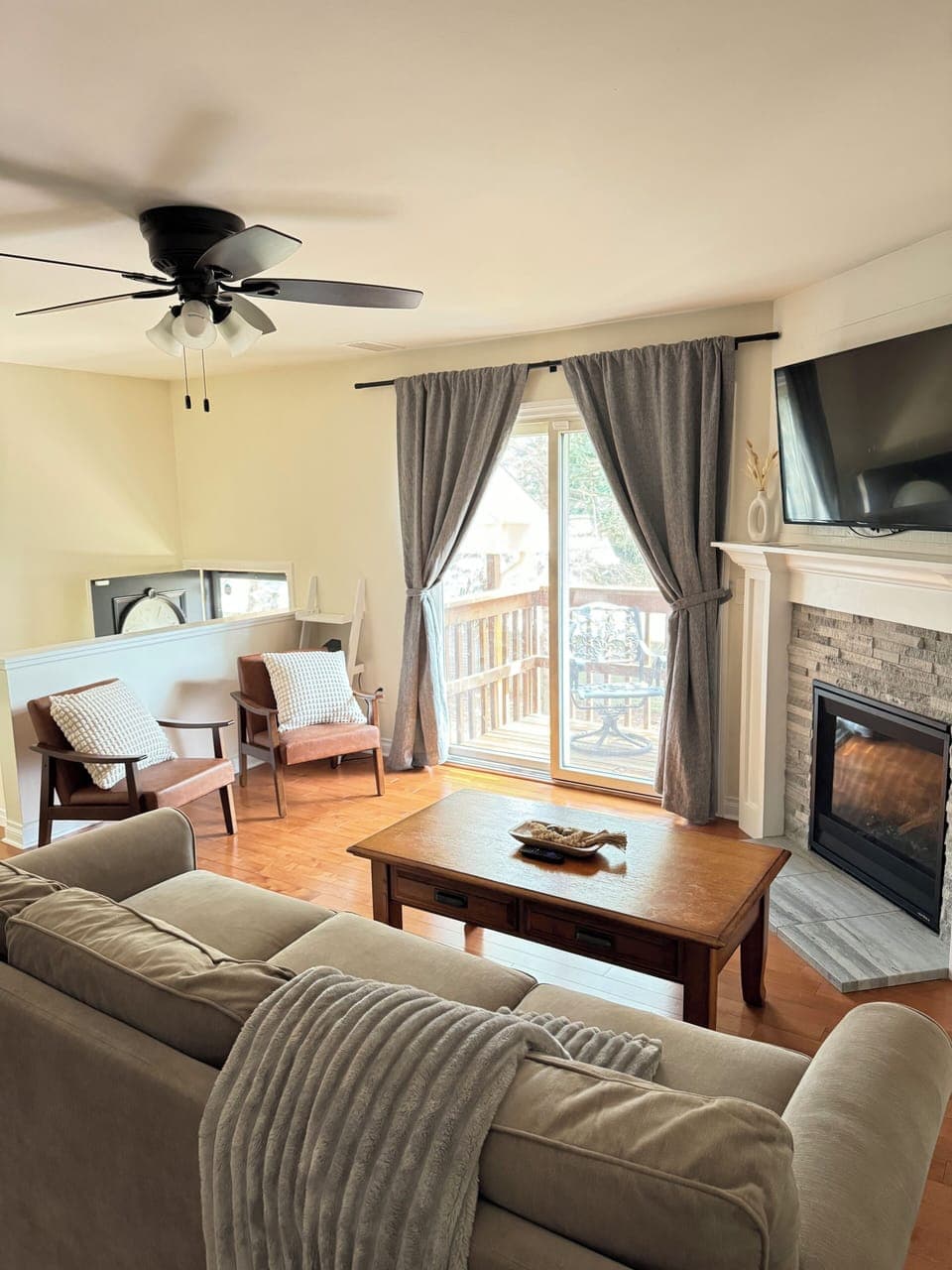 Living Room w/ Couch, Two Oversized Faux Leather Chairs, and a 50-inch Smart TV with Roku. 
