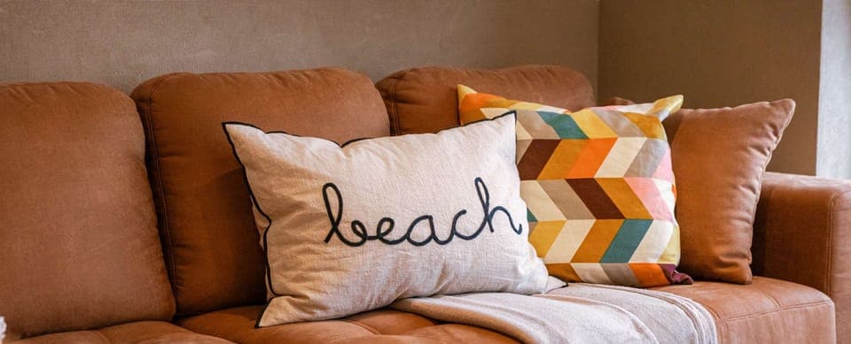 Cozy corner sofa with textured cushions and a welcoming beach vibe.