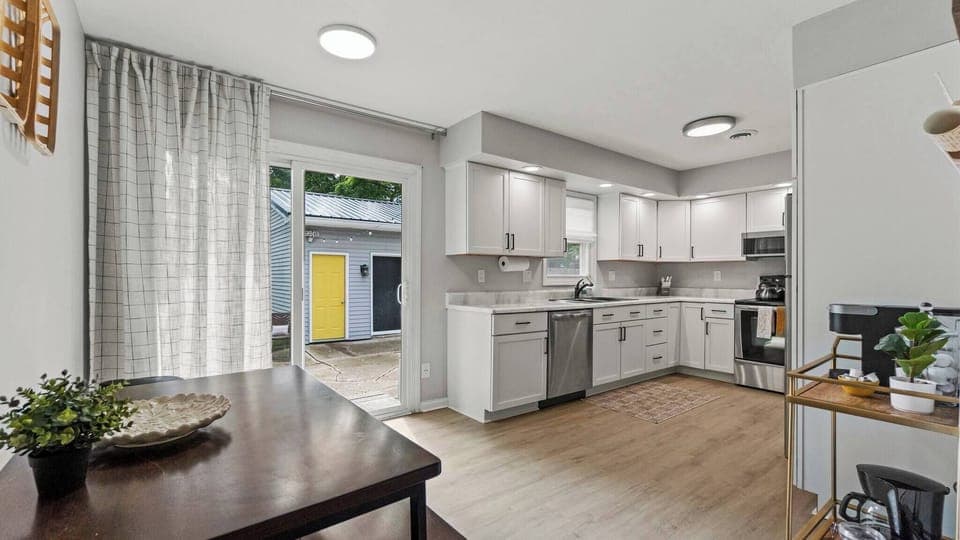 Kitchen and dining area with exit through sliding glass doors to backyard seating area. 