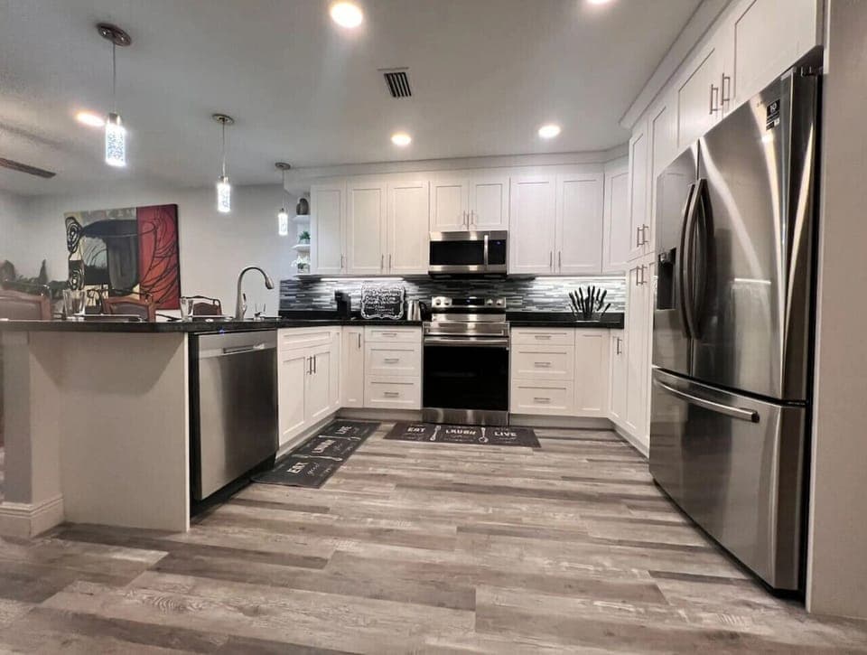 Fully Renovated kitchen with quartz countertops stainless steel appliances & bar seating