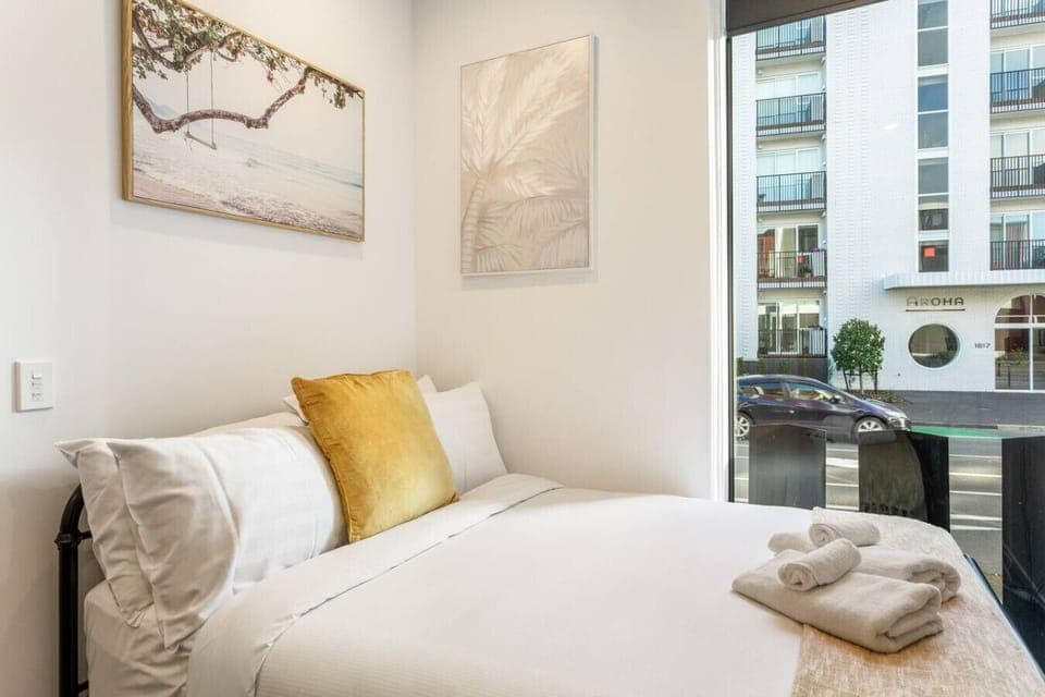 The studio has a kitchenette, a full bathroom, and a bed in the living area.