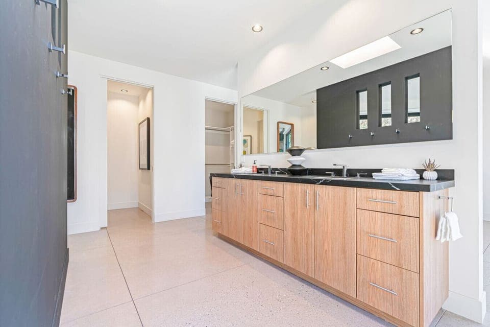 Streamlined vanity area w/ double sinks, wood cabinetry, and plenty of counter space for easy mornings.