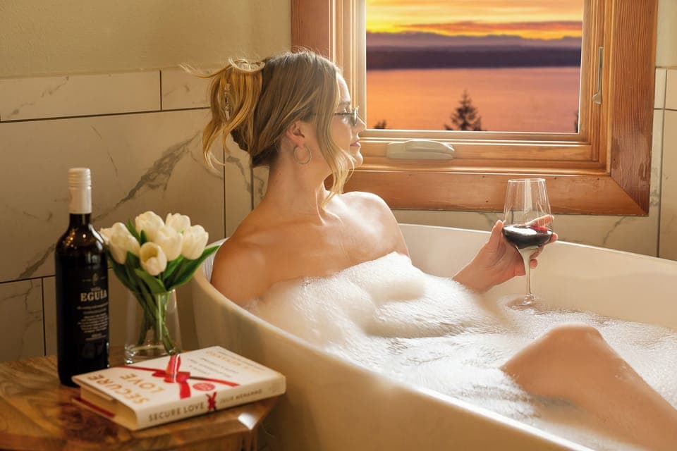 Unwind in a bubbly bath with wine, enjoying stunning sunset views