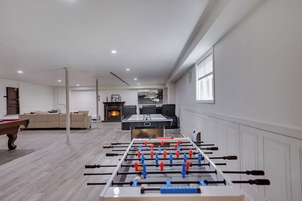 🎮 Ultimate Game Room Retreat — Enjoy foosball, ping-pong, cozy lounge seating, and a warm fireplace — the perfect hangout spot for family fun and rainy-day entertainment.