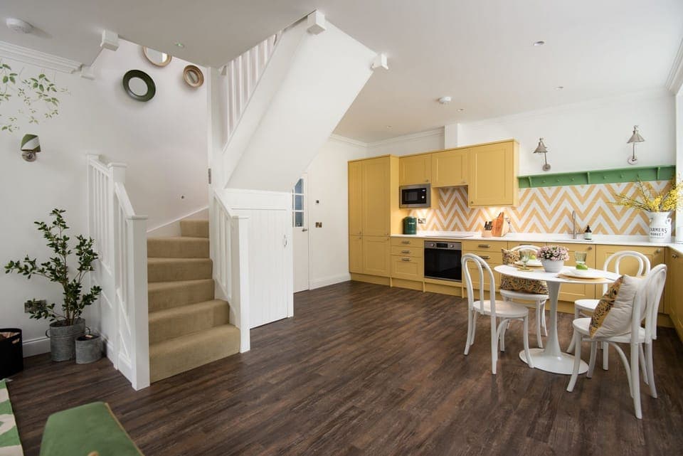Grooms Cottage - the kitchen brings a cheerful pop of colour to the open-plan living space