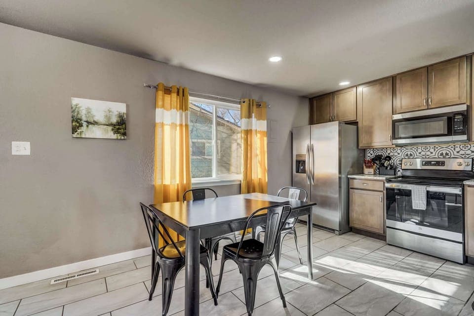 Gather around the dining table in this sunlit space, perfect for sharing meals, game nights, or a morning coffee.





